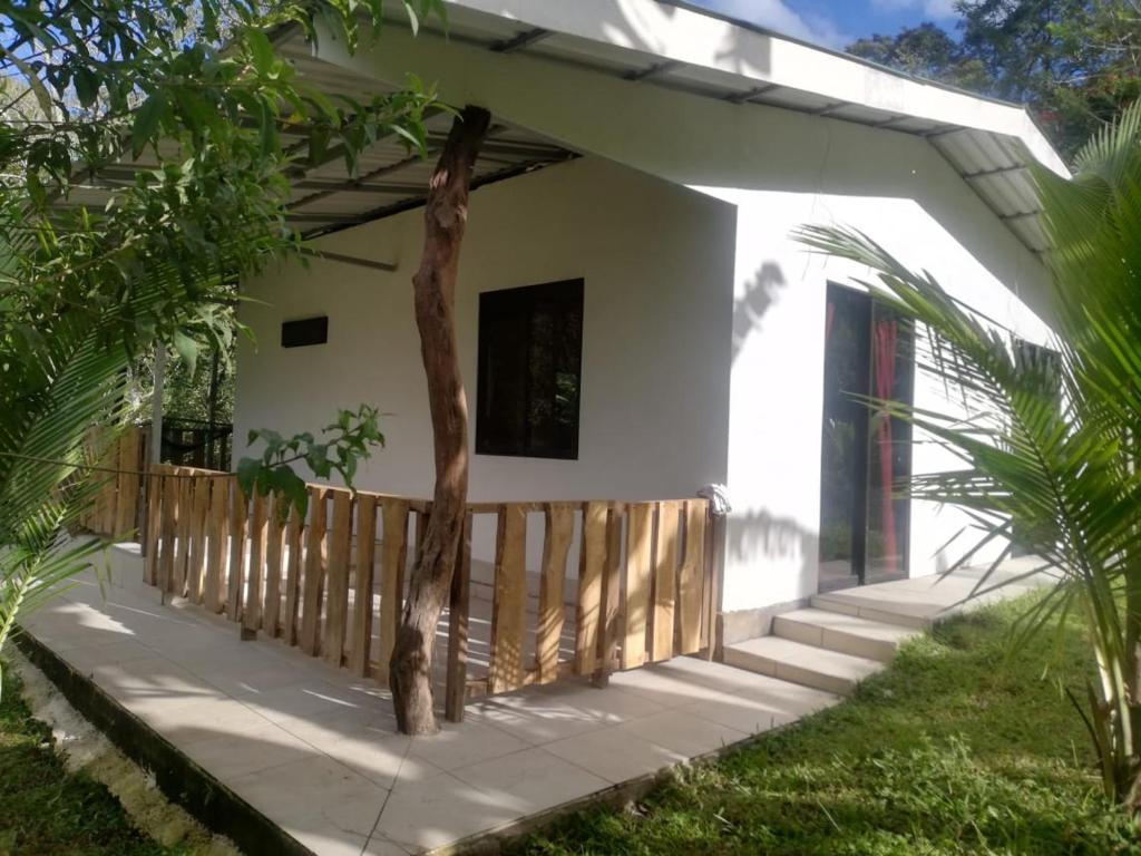 a white house with a wooden fence and stairs at Casa el Colibrí in Naranjo