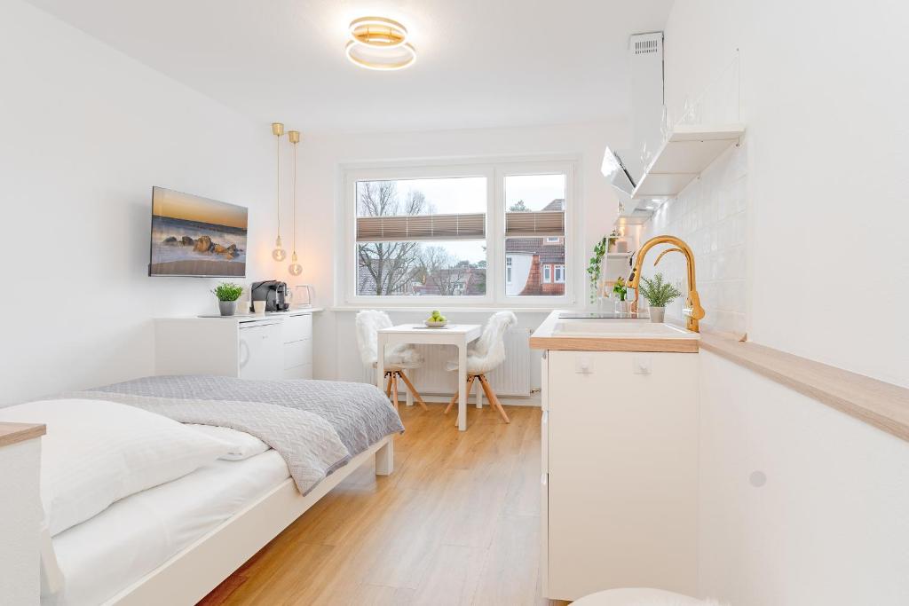 um quarto branco com uma cama e uma cozinha em Beach Vibes em Timmendorfer Strand