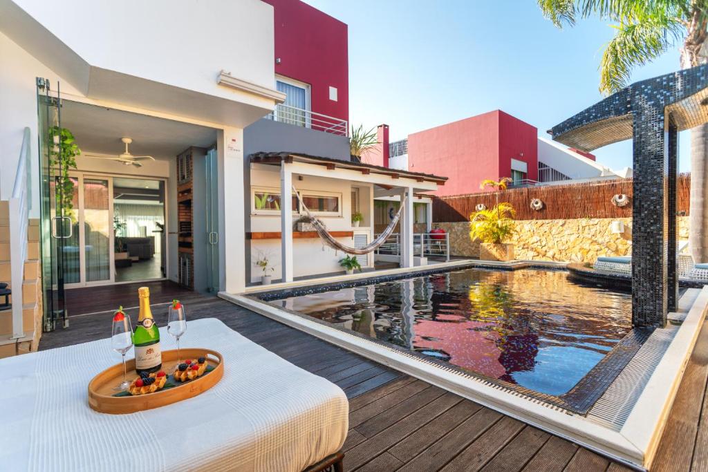 uma casa com uma piscina e uma mesa com uma garrafa de vinho em Host Wise - Luxurious House with Private Salt Pool em Ferragudo