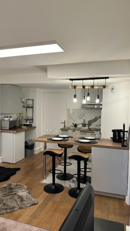 une cuisine avec une table et quelques chaises dans une pièce dans l'établissement Appartement 5min to DisneyLand, parking privé, à Magny-le-Hongre