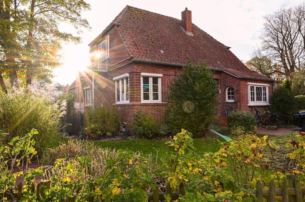 una casa di mattoni con il sole che splende alla finestra di Ferienwohnung Veras Kate a Greetsiel