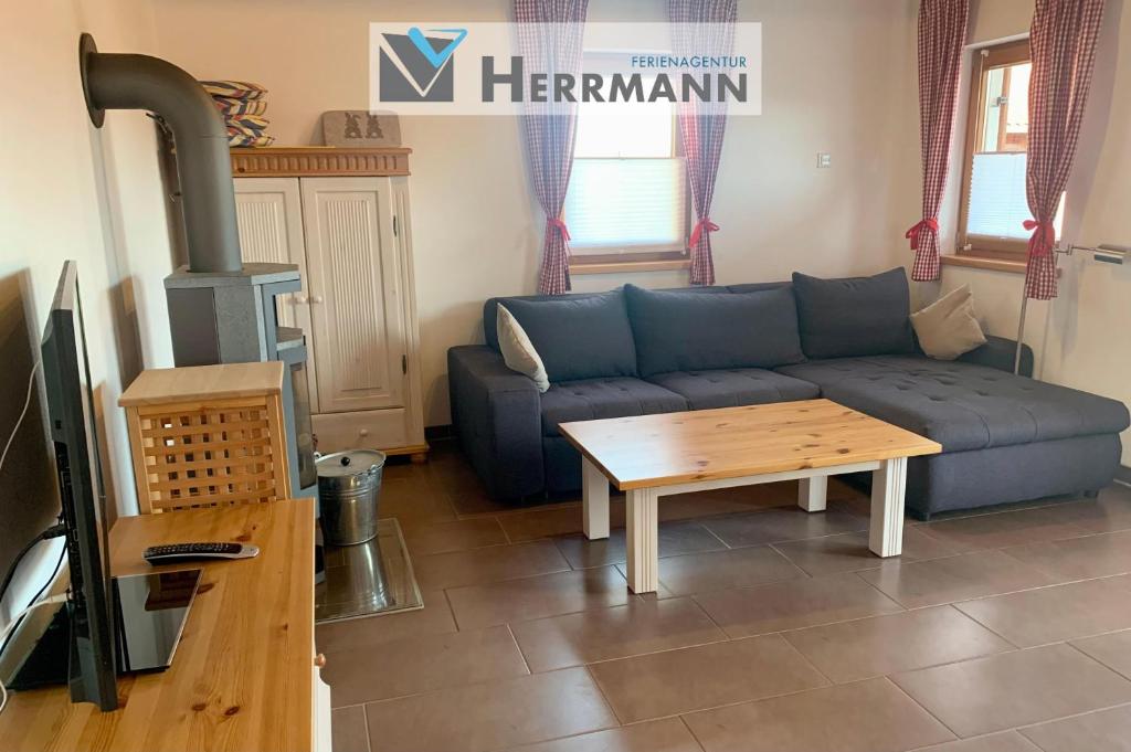 a living room with a blue couch and a table at Feriendorf Via Claudia Ferienhaus Lechsee in Lechbruck