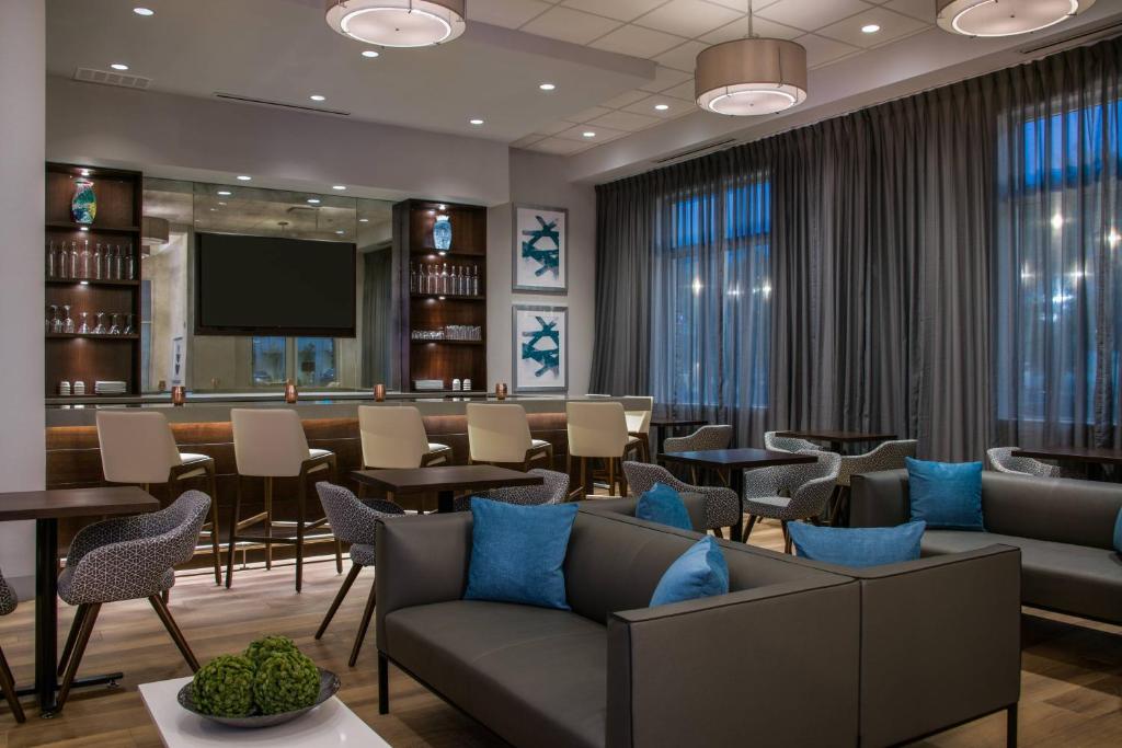 Fairfield Inn & Suites by Marriott Dayton في دايتون: غرفة انتظار مع كنب وطاولات وبار