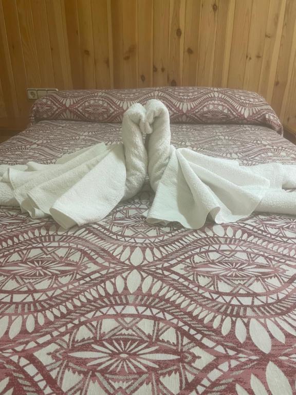 a bed with a white blanket on top of it at La Posá in Villar del Arzobispo