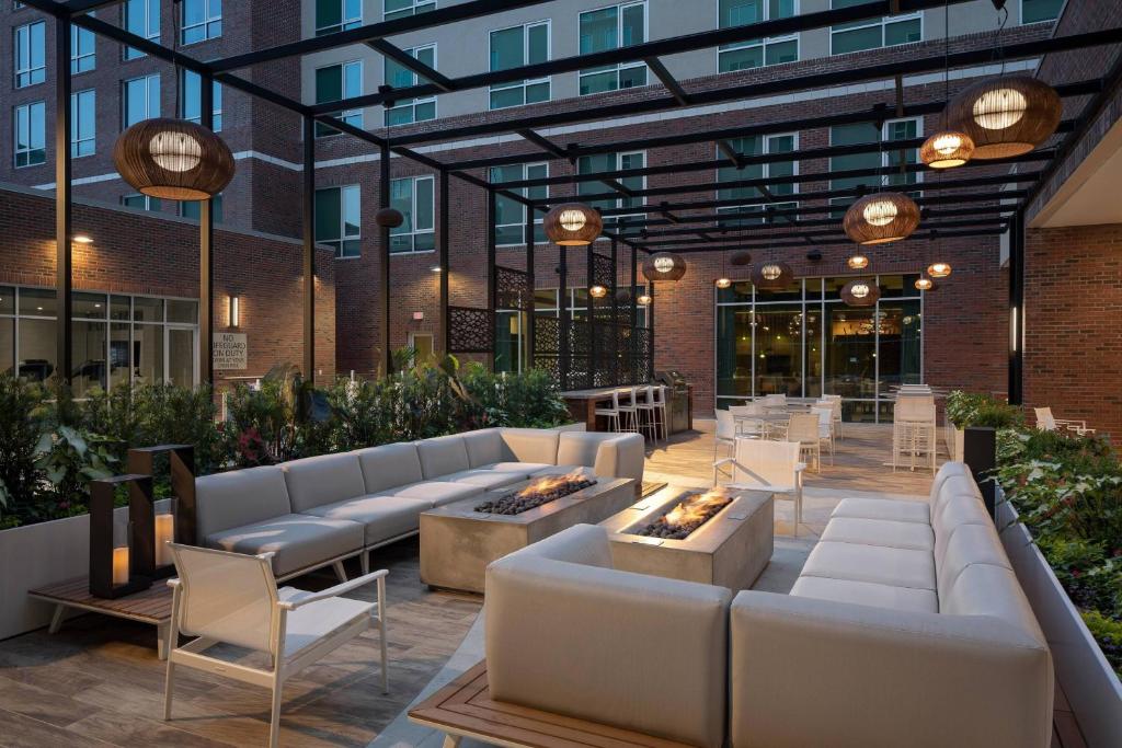 um pátio com sofás e mesas e um edifício em SpringHill Suites by Marriott Greenville Downtown em Greenville