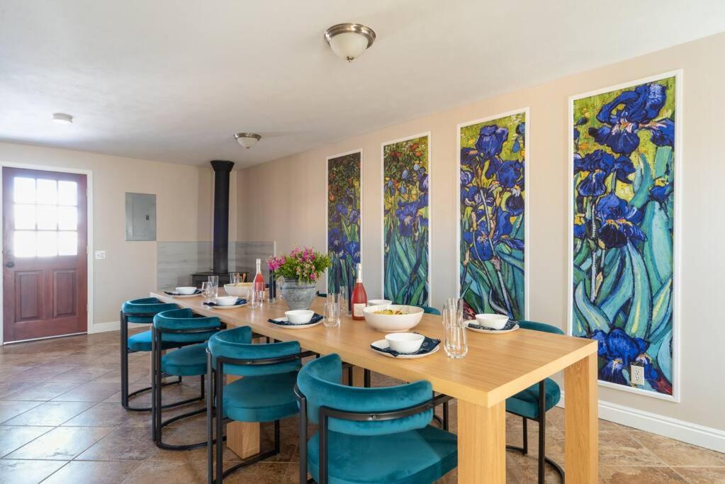 a dining room with a long table and blue chairs at Downtown Denver: 4bd - Game/Movie Room - Backyard in Arvada