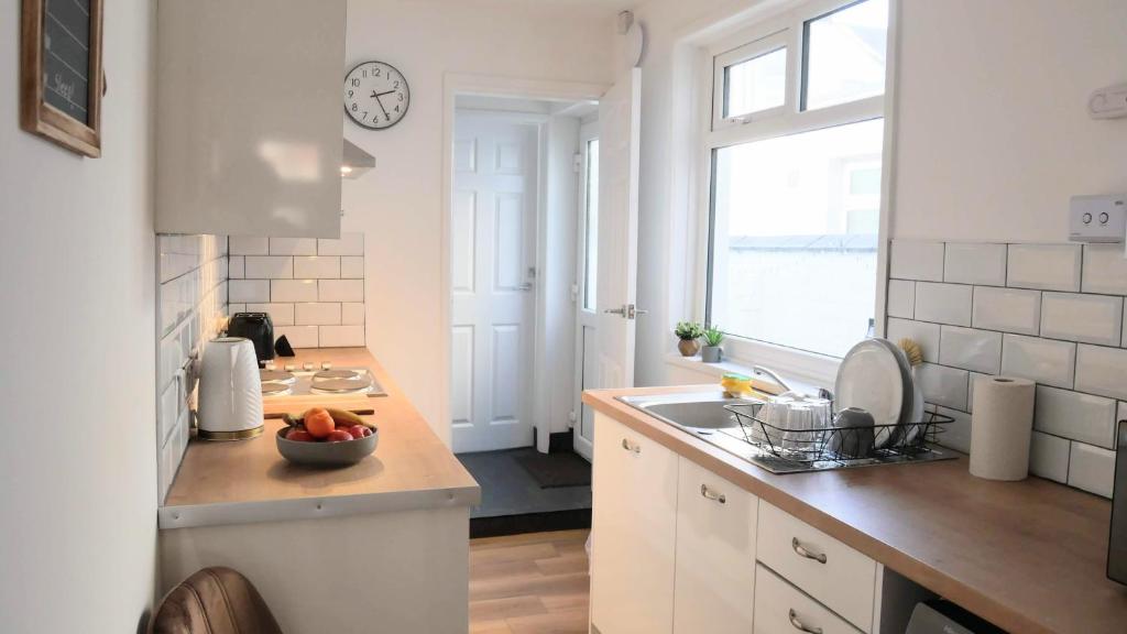 a kitchen with a bowl of fruit on a counter at Stoke - 3 Bedroom House - Winifred St. in Stoke on Trent