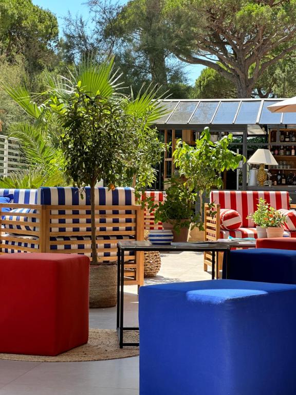 a patio with tables and chairs and plants at MARITTIMO Milano Marittima in Milano Marittima