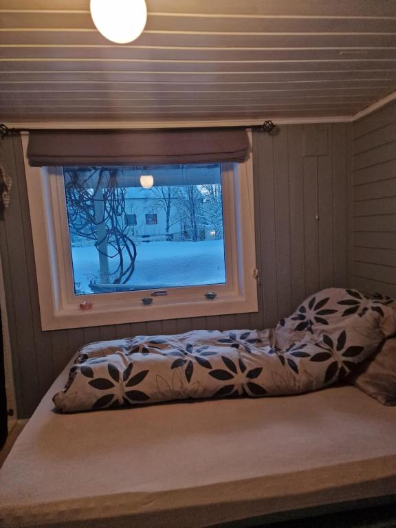 a bed in a room with a window at Sør-tromsøya in Tromsø