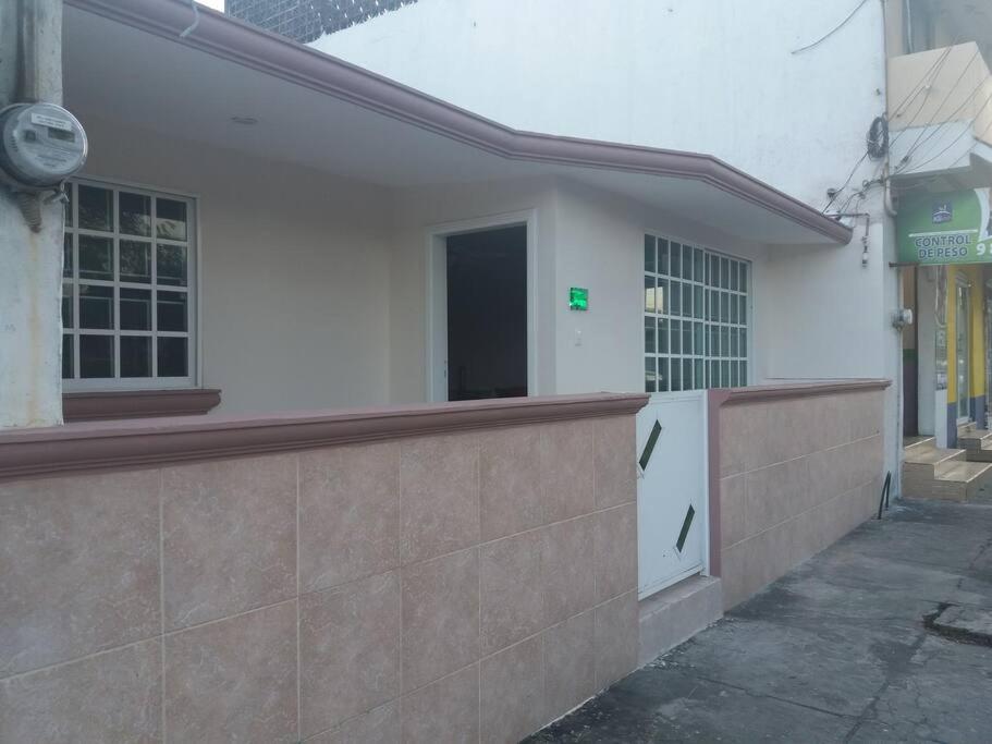 a white building with a gate and a door at Preciosa casa totalmente amueblada y equipada. in Veracruz
