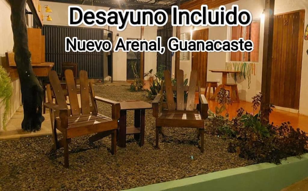 twee houten stoelen en een tafel in een kamer bij Cabinas Morpho Gardens in Nuevo Arenal