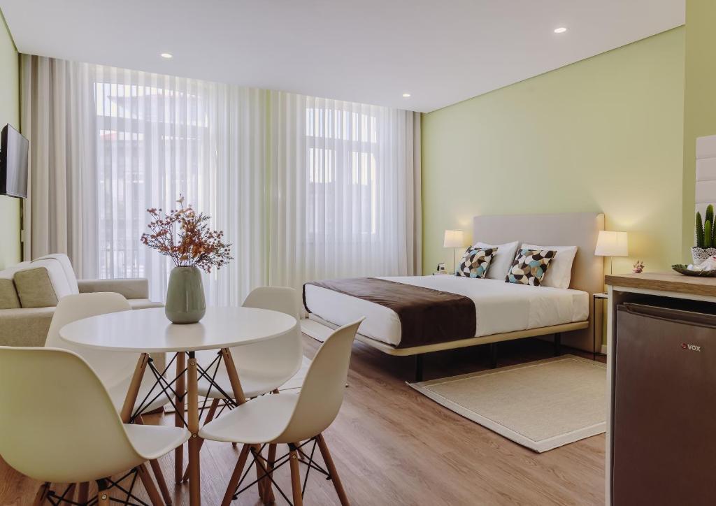 a bedroom with a bed and a table and chairs at Primeiro Quartel Apartments - 2 in Peso da Régua