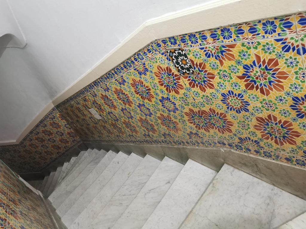 a staircase with a colorful tile wall and a stair case at Dar mima baya in Tunis
