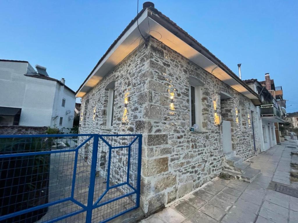 a stone house with a blue gate on a street at Filipa Gardens in Limenas