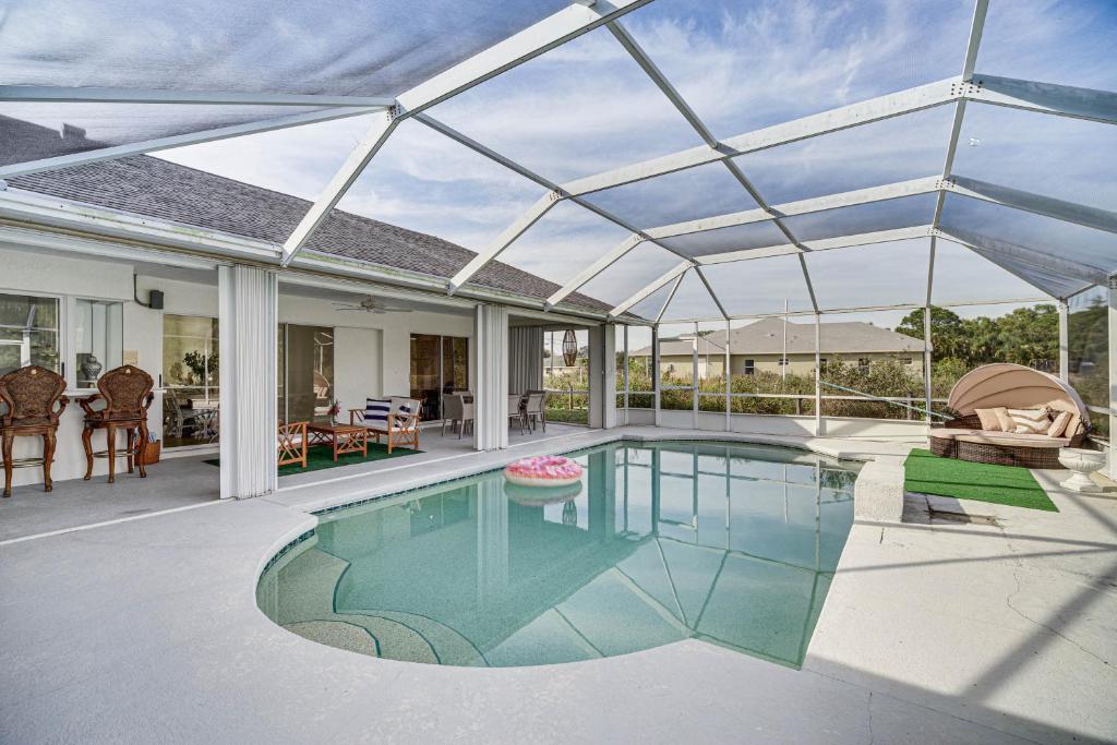 een zwembad in een huis met een glazen dak bij Port St Lucie Canal-Front Home with Private Pool! in Port Saint Lucie