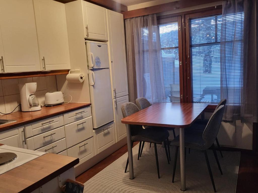 a kitchen with a table and chairs and a window at Loma-asunto Tahkon ytimessä in Kuopio