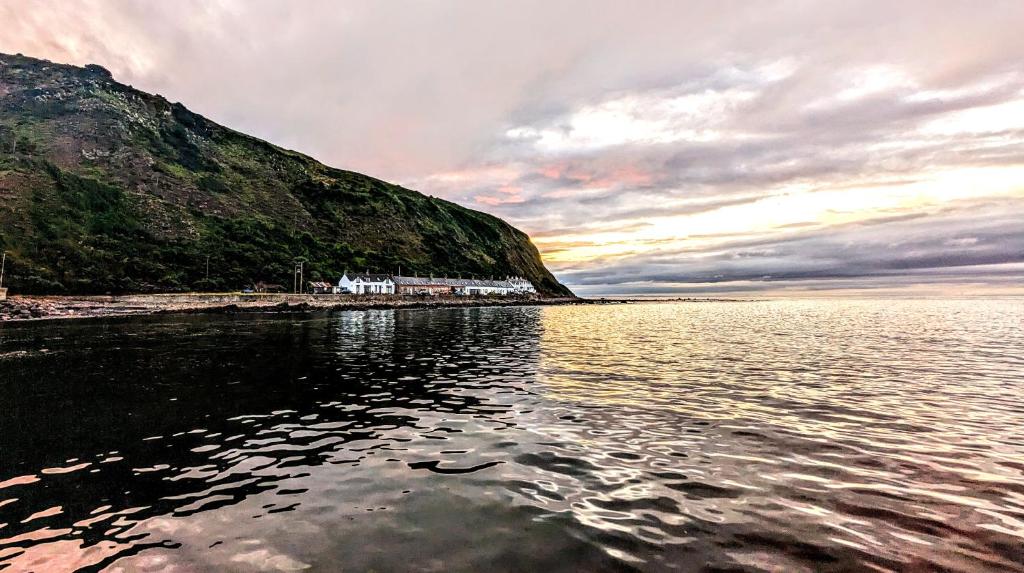 Blick auf einen Wasserkörper mit einem Berg in der Unterkunft The Cottage By The Sea, Scotland in Burnmouth