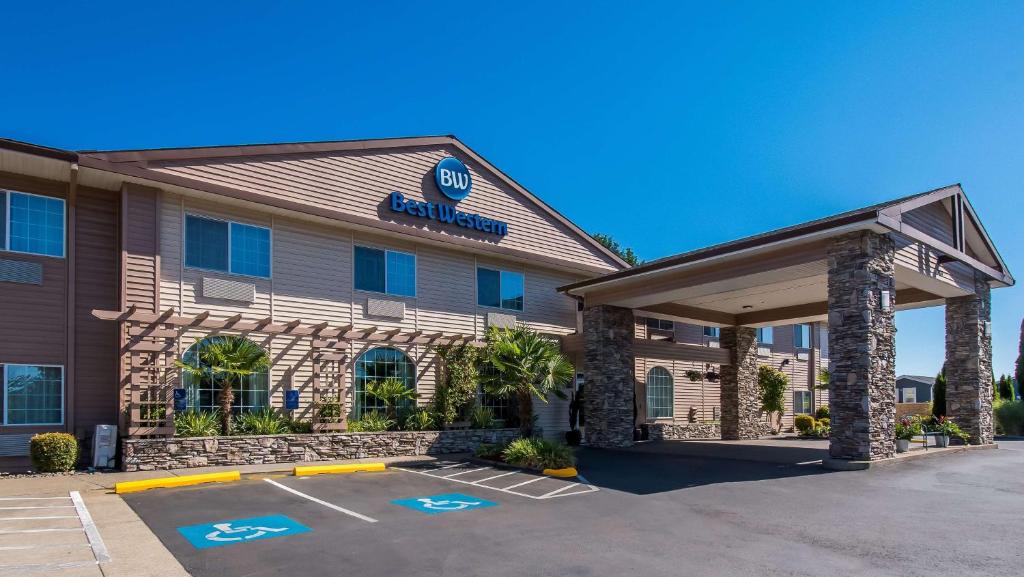 ein Hotel vor einem Gebäude mit einem Parkplatz in der Unterkunft Best Western University Inn and Suites in Forest Grove