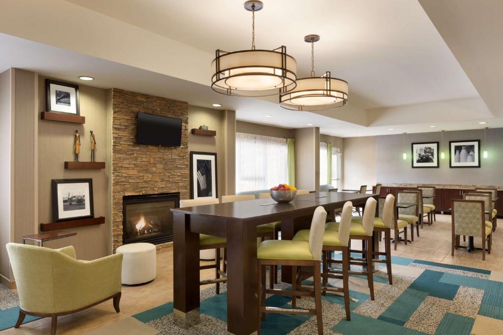 a dining room with a table and chairs and a fireplace at Hampton Inn Denville-Rockaway-Parsippany in Denville