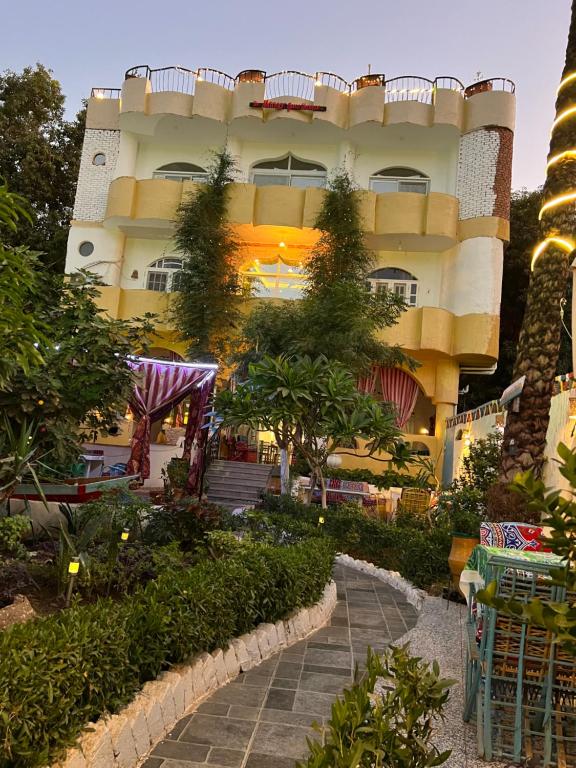 a large building with a garden in front of it at The Mango Guest House in Aswan