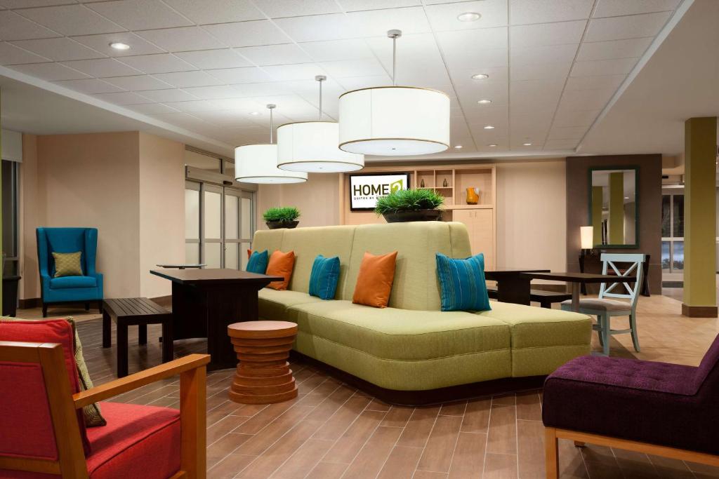 a lobby with a green couch with colorful pillows at Home2 Suites by Hilton Rahway in Rahway