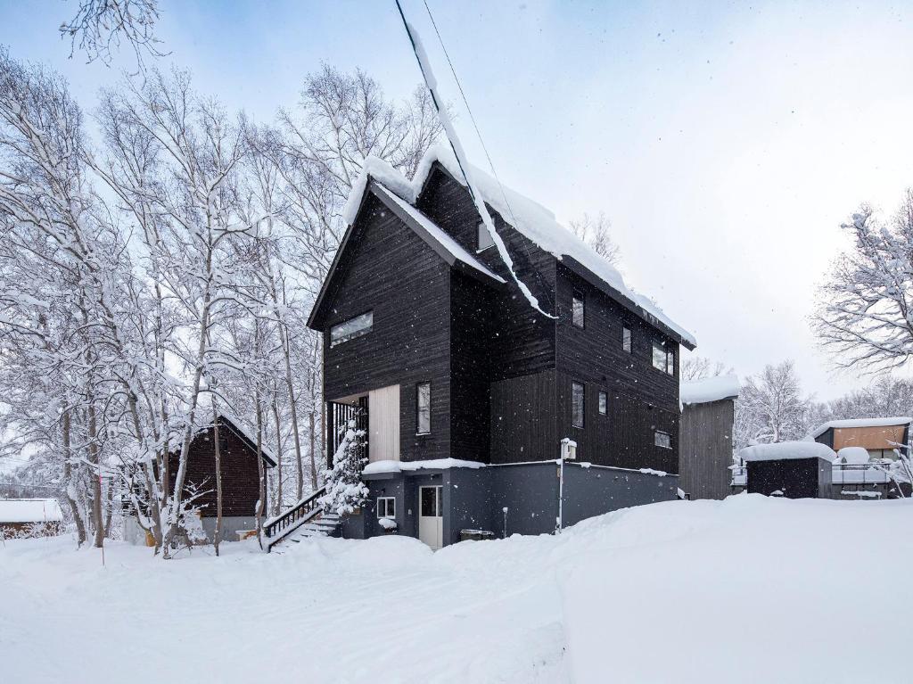 ニセコ町にあるShousugi Chalet by Elite Havensの屋根に雪が積もった黒い建物