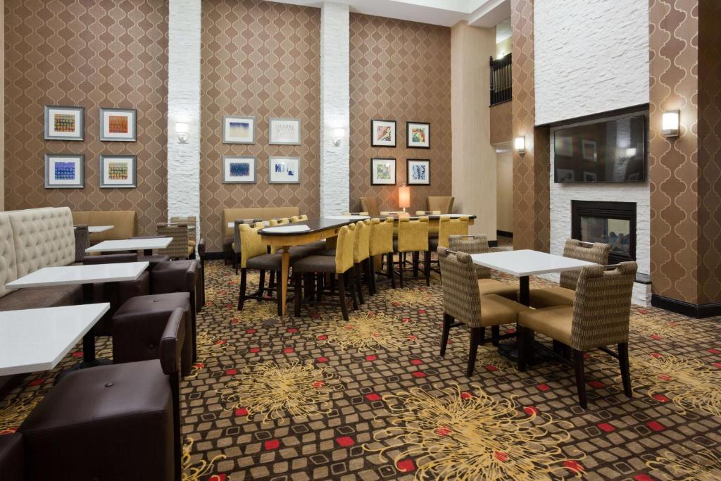restauracja ze stołami i krzesłami oraz kominkiem w obiekcie Homewood Suites by Hilton Sioux Falls w mieście Sioux Falls