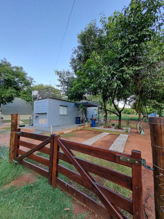 a wooden fence in front of a house at Casa Container Camisão 