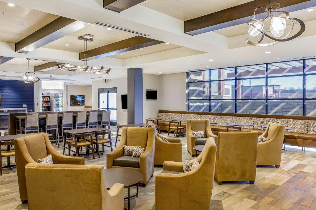 uma sala de jantar com mesas, cadeiras e janelas em SpringHill Suites by Marriott Topeka Southwest em Topeka