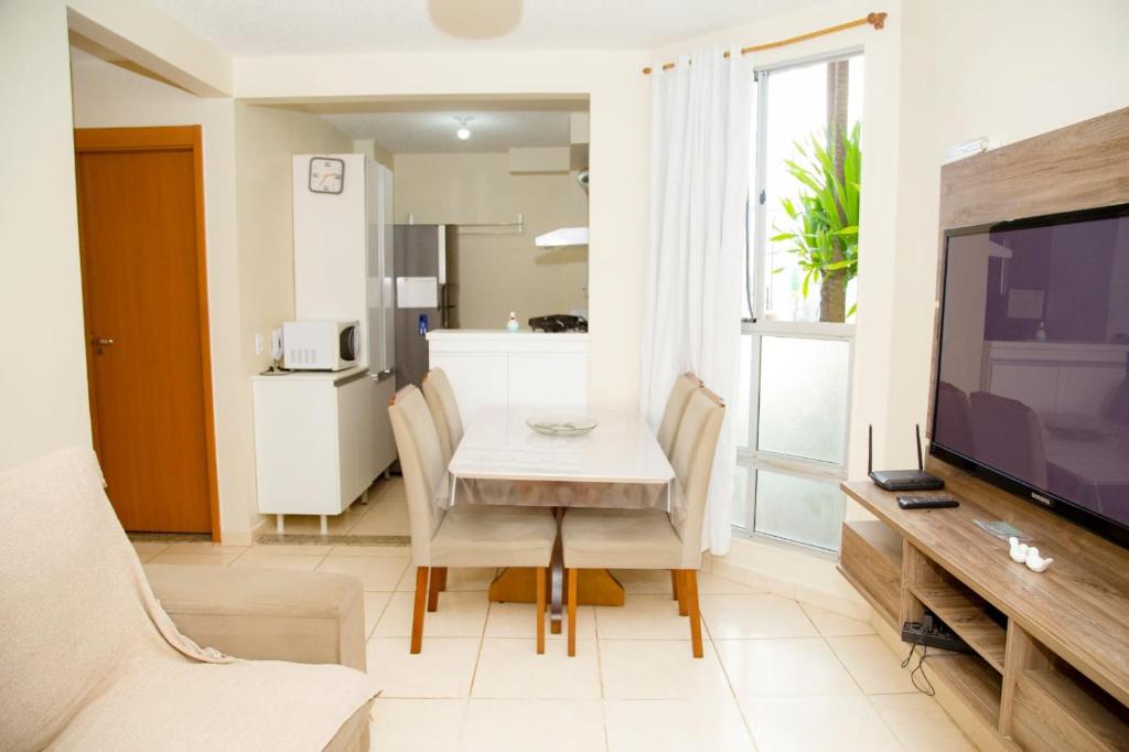 ein Wohnzimmer mit einem Esstisch und einem TV in der Unterkunft Conforto & tranquilidade in Rio das Ostras