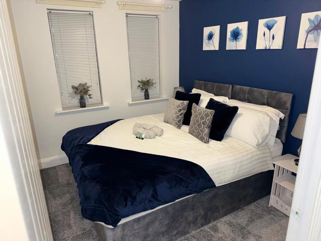 a bedroom with a bed with a teddy bear on it at Blue Madison in Aldershot