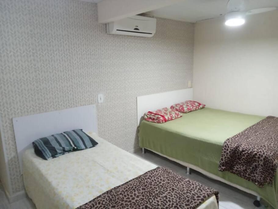 a room with two beds in a room at Praia de Geribá e piscina para sua família! in Búzios