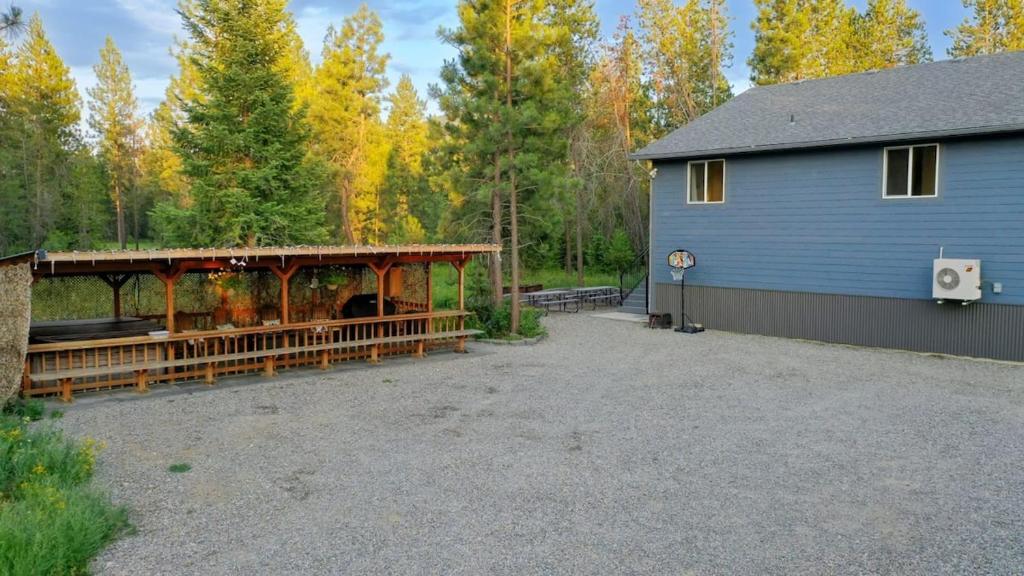 a garage with a pavilion next to a house at Pinetree Lodge: Hot Tub Fire Pit in Athol