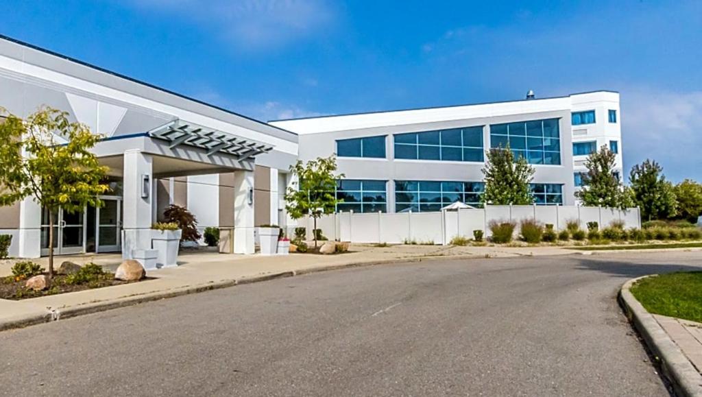 an office building with a road in front of it at Wyndham Flint MI Grand Blanc Bishop Airport Conference Ct in Flint