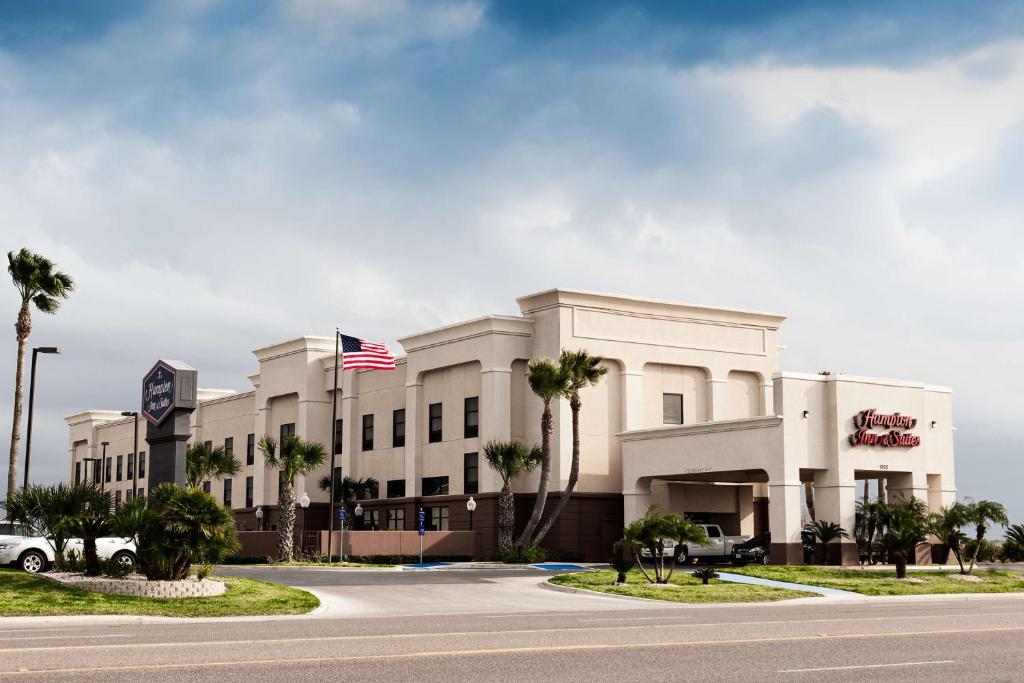 ein Bürogebäude mit Palmen davor in der Unterkunft Hampton Inn & Suites Harlingen in Harlingen