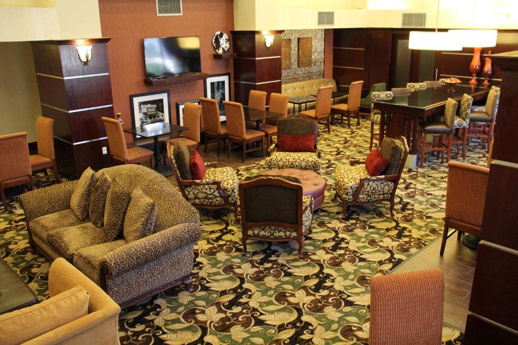 a lobby with a waiting room with chairs and a piano at Hampton Inn and Suites Houston-Katy in Katy
