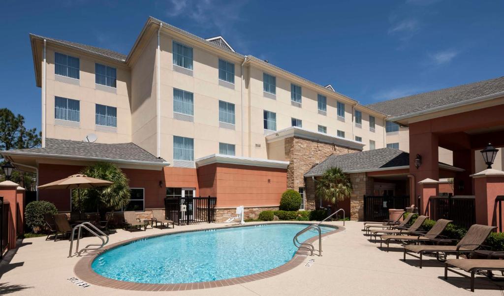 ein Hotel mit einem Pool vor einem Gebäude in der Unterkunft Homewood Suites by Hilton Houston Stafford Sugar Land in Stafford