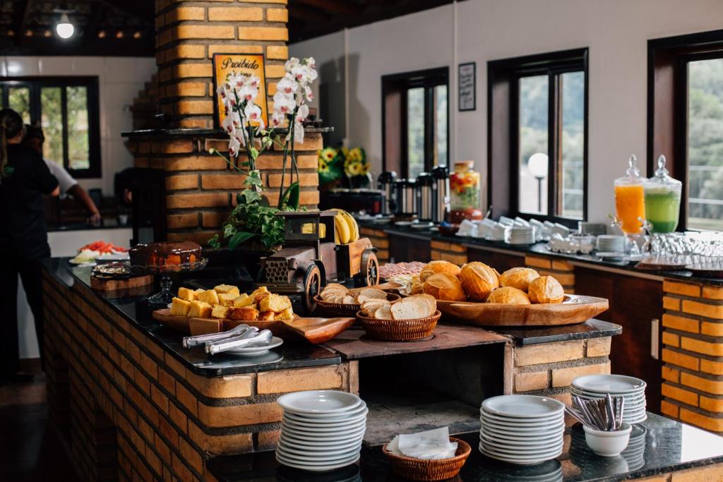 a breakfast buffet with bread and pastries on a table at Espaco Villa Verde LTDA in Ibiúna