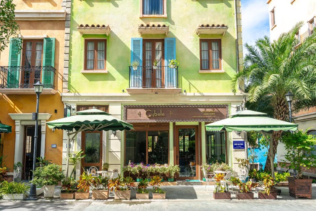 a building with two umbrellas in front of a store at Cybele Sunset Hotel Phu Quoc in Phu Quoc