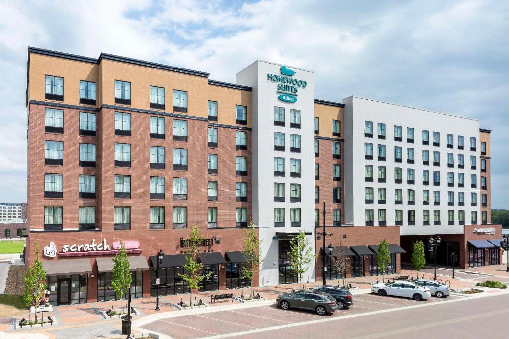 a hotel with cars parked in front of a building at Homewood Suites by Hilton Coralville - Iowa River Landing in Coralville