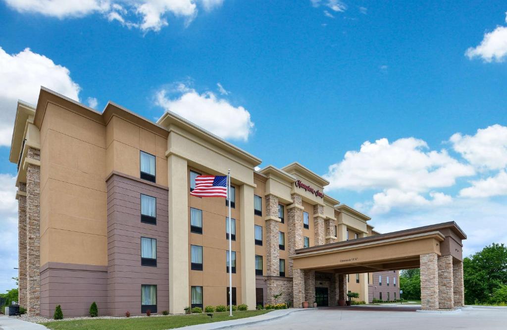 a hotel with an american flag in front of it at Hampton Inn Iowa City/University Area in Iowa City