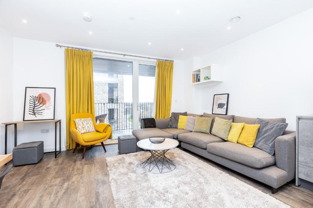 sala de estar con sofá gris y silla amarilla en New 2BR wBalcony 1 min Ponders End Train, Enfield en Ponders End