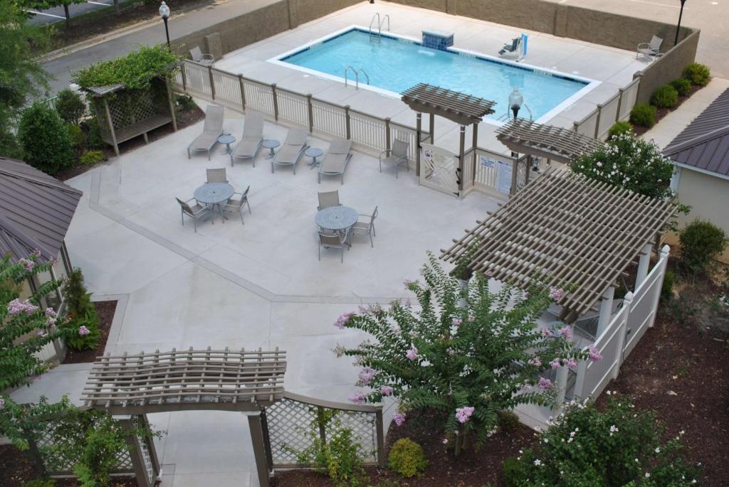 una vista sul soffitto di una piscina con sedie e tavoli di DoubleTree by Hilton Fayetteville a Fayetteville