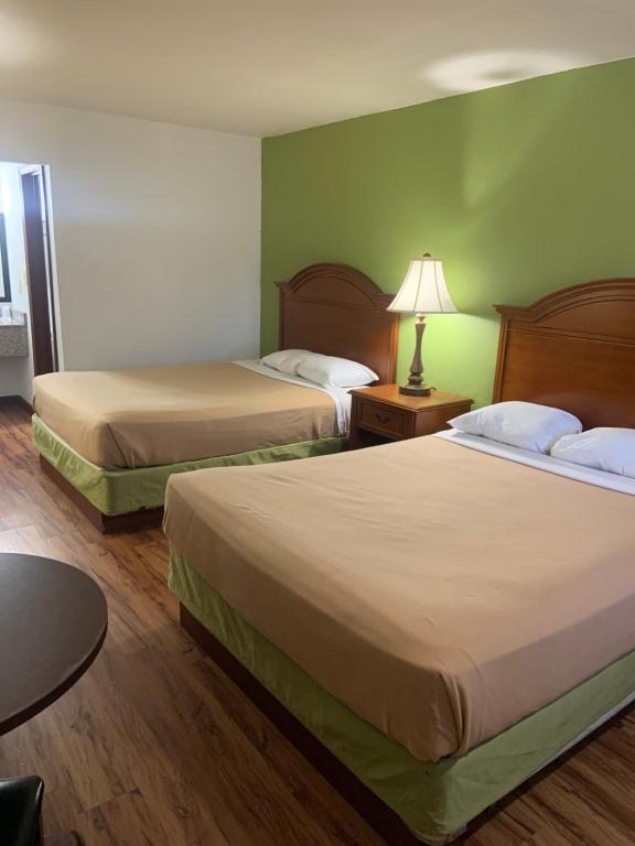 2 camas en una habitación de hotel con paredes verdes en Relax Inn & Suites en Mattoon