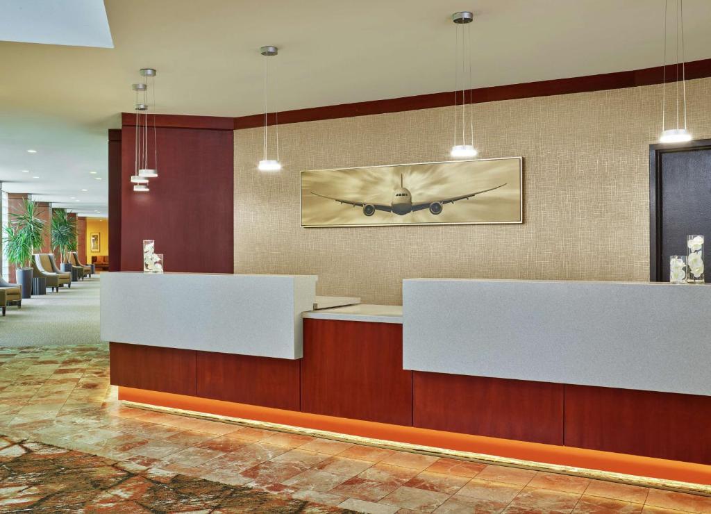 a lobby with two reception desks and a picture of a plane at DoubleTree by Hilton Houston Intercontinental Airport in Houston
