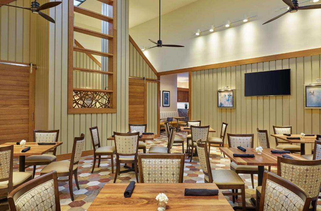 a restaurant with tables and chairs and a flat screen tv at DoubleTree by Hilton Houston Intercontinental Airport in Houston