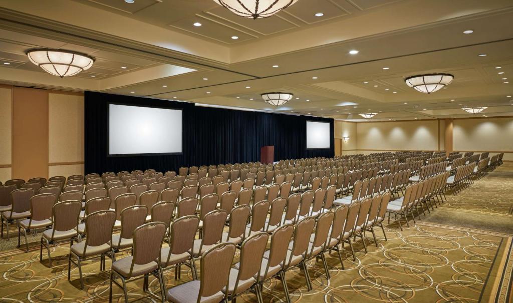 a conference room with chairs and a projection screen at DoubleTree by Hilton Houston Intercontinental Airport in Houston