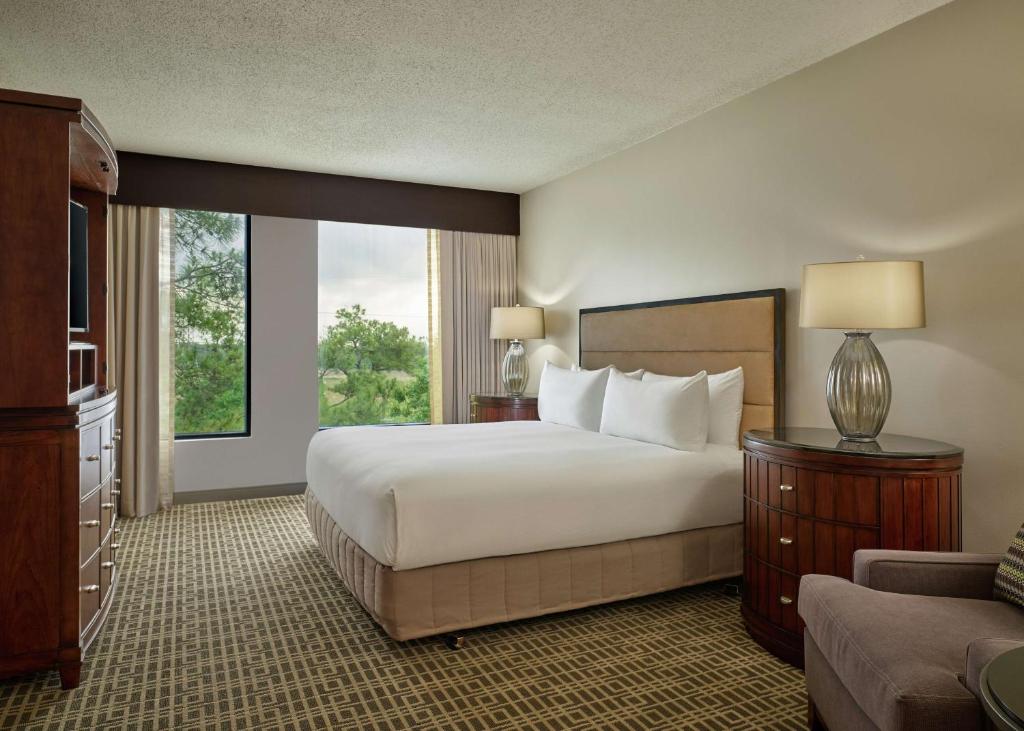 a hotel room with a bed and a large window at DoubleTree by Hilton Houston Intercontinental Airport in Houston