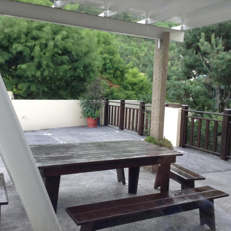 a wooden picnic table on a patio with a tree at Yun Wu B&amp;B in Ren&#39;ai