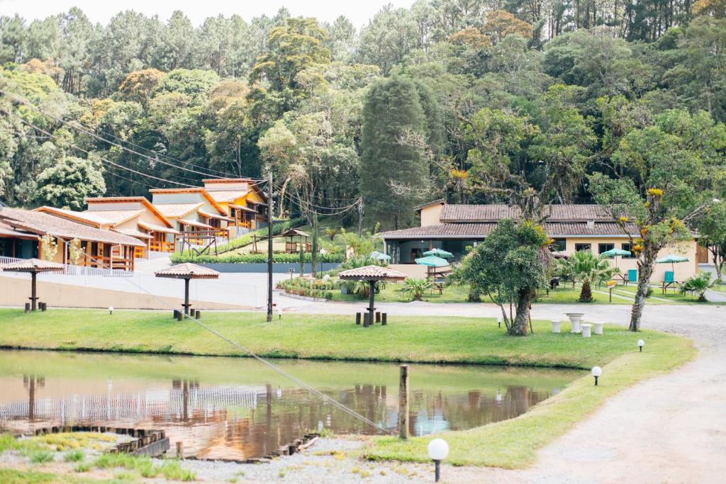 a village with a pond and buildings and trees at Espaço Villa Verde in Ibiúna